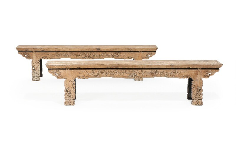 NOT SOLD. A pair of Chinese hardwood benches with remnants of black paint, richly carved...