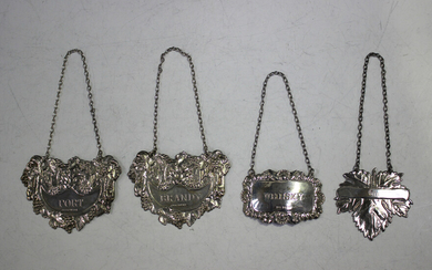 A pair of Elizabeth II silver decanter labels, each decorated in relief with a lion's mask and