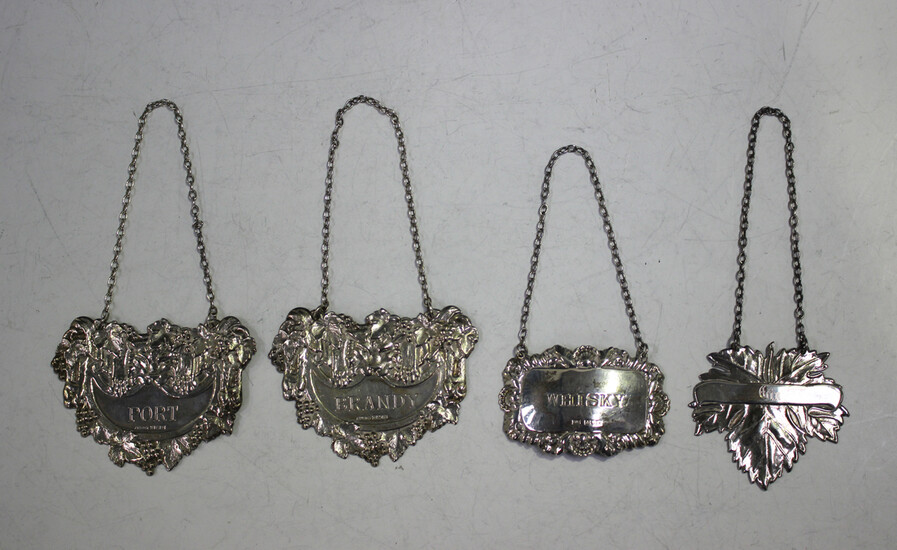 A pair of Elizabeth II silver decanter labels, each decorated in relief with a lion's mask and