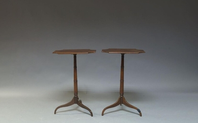 A pair of mahogany tripod occasional tables, 19th century, the shaped oblong tops, raised on turned columns and standing on three sabre legs, 74cm high, 49cm wide, 35cm deep