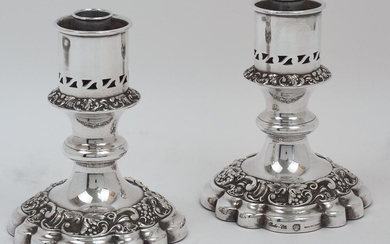 A pair of silver plated candlesticks, Barker Ellis, each with pierced sconce above bands of grape vines and C-scrolls, on a shaped spreading foot, stamped BARKER-ELLIS MADE IN ENGLAND to foot, 14.5cm high (2) ( VAT charged on the hammer price)