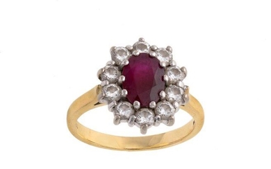 A ruby and diamond ring, cluster design, centring on an oval ruby surrounded by brilliant-cut diamonds, ring size L, British hallmarks for 18-carat gold