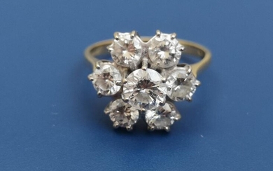 A seven stone diamond cluster ring, the largest brilliant...