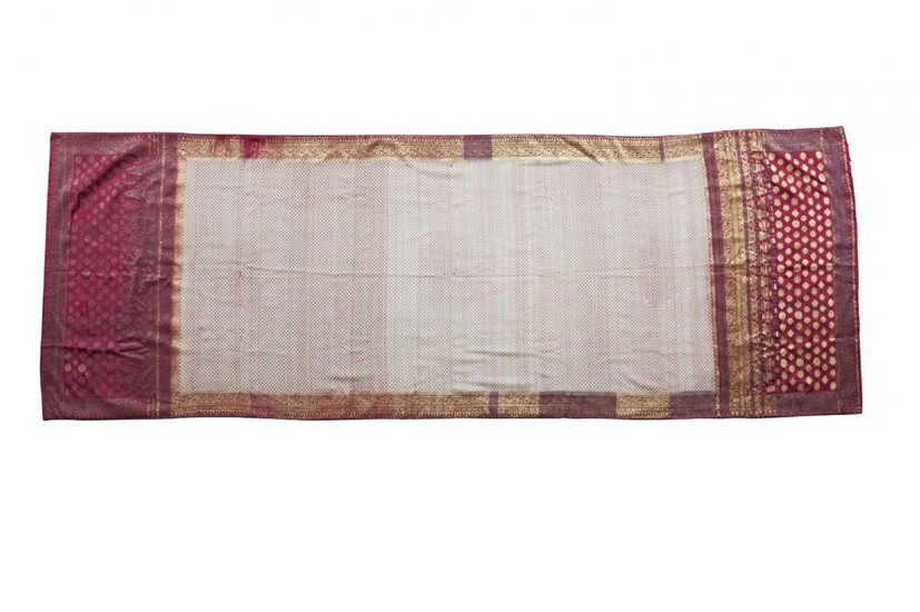 A shoulder cloth or Selendang (ceremonial robe), Sumatra, Indonesia, 20th century, the scarlet silk ground woven with a white and red lattice grid to the field, within borders worked with gilt metal stars and ogival motifs, 96 x 270 cm. Provenance:...