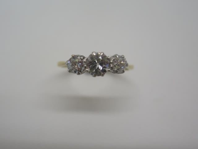 A yellow gold three stone diamond ring tests to approx 18ct,...