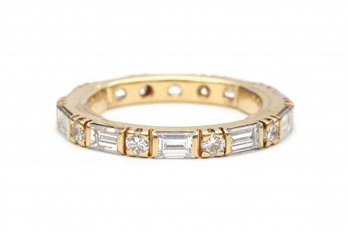 An 18 carat gold diamond eternity ring. Featuring ten brilliant cut and ten baguette cut diamonds, in total ca. 1.90 ct., ca. H-I, ca. VS. Gross weight: 3.3 g.