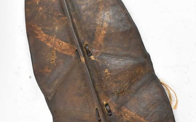 An African hide shield with traces of painted decoration to...
