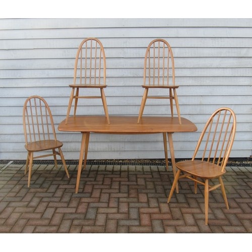 An Ercol light elm dining table and four high hoop back chai...