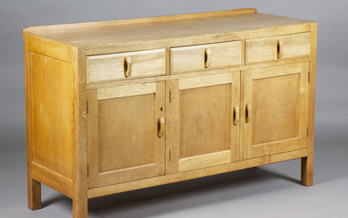 An early 20th century Heals pale oak sideboard, fitted with three drawers above panelled cupboard do