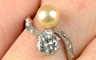 An early 20th century platinum, circular-cut diamond and pearl crossover ring.