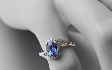 Asymmetrical ring in 750 thousandths white gold set in its centre with an oval-cut sapphire calibrating approximately 1.30 carats decorated with two lines of modern