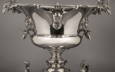 Important silver centrepiece bowl flanked by eagle heads, cherubs on the foot and hazelnuts, it rests on a round base applied with cherubs' heads in bas-relief, it rests on three scrolled legs overhung with figures in a humped bust holding an eagle