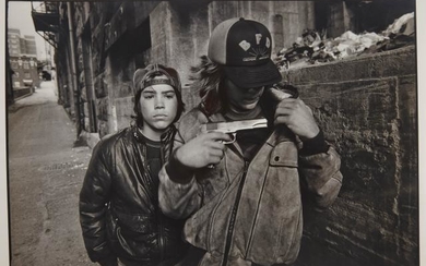 MARK, MARY ELLEN (1941-2015) Seattle, [Rat and Mike with a gun], 1983. Gelatin silver print, 12 1/2 x 18 3/4 inches (320 x...