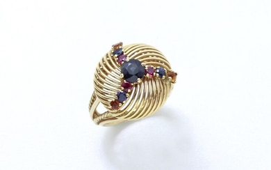 Ring in partially twisted 750 thousandths gold wire, stylizing a button centered with a round facetted sapphire in claw setting, enhanced with small rubies, sapphires and citrines. Circa 1950/60. (scratched)