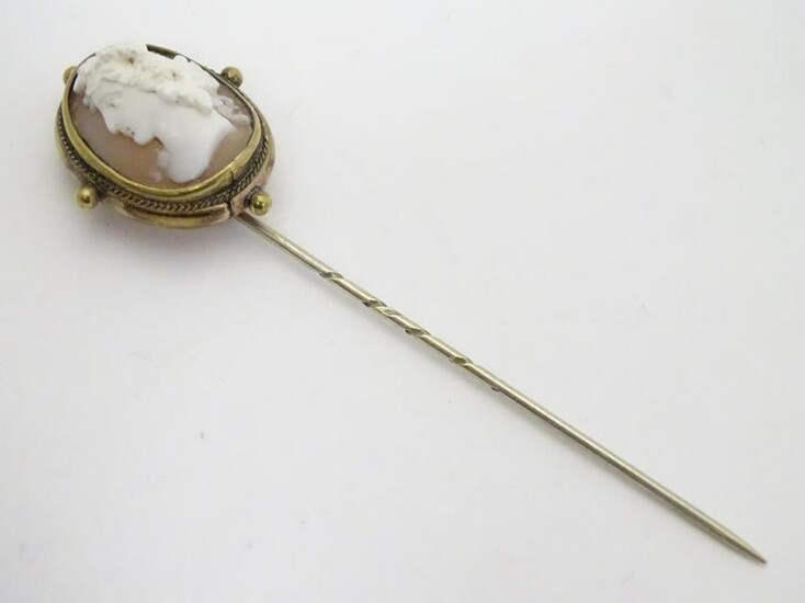A 19thC gilt metal stick pin surmounted by a Victorian
