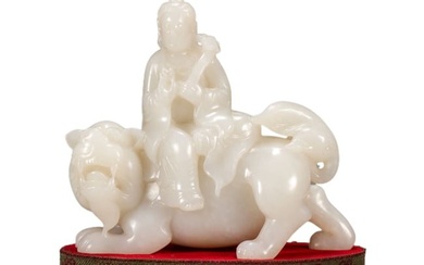 A CHINESE CARVED WHITE JADE FIGURE ON BEAST