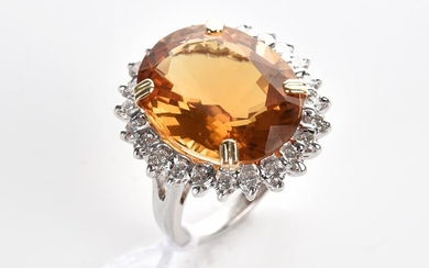 A CITRINE AND DIAMOND COCKTAIL RING IN 18CT TWO TONE GOLD, THE OVAL CUT CITRINE WEIGHING 13CTS, IN A SURROUND OF DIAMONDS TOTALLING...
