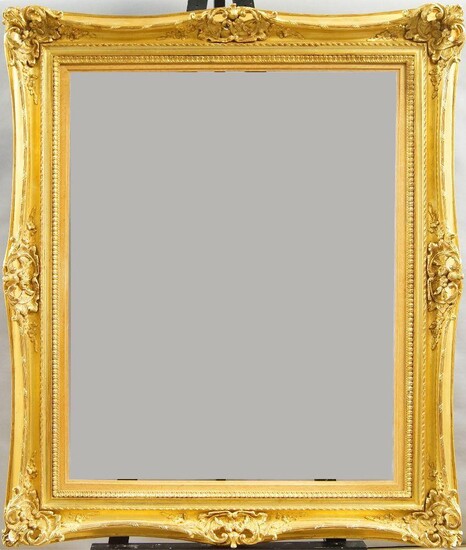 A Gilded Composition Louis XV Style Double Swept and Pierced Frame, late 20th century, with rais-de-coeur sight, plain hollow, ribbon-and-stick, the plain hollow with foliate and flower head scrollwork cartouche centres and corners, with added oak...
