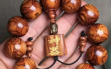 A HUANGHUALI WOOD STRING BRACELET WITH 12 BEADS