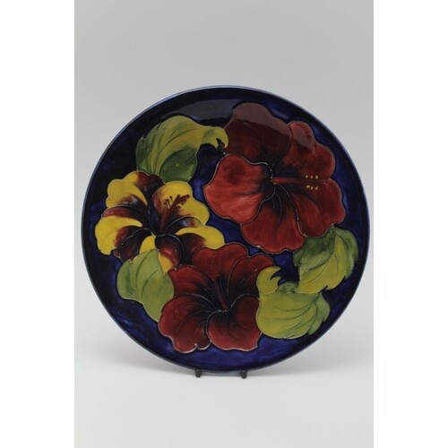 A MOORCROFT POTTERY PLATE, tube lined and painted with three...