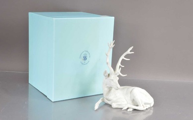 A Nymphenburg white bisque porcelain figure of a resting stag