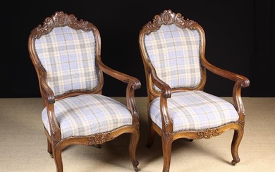 A Pair of Carved Walnut Fautieul Armchairs. The upholstered cartouche backs and sprung seats covered