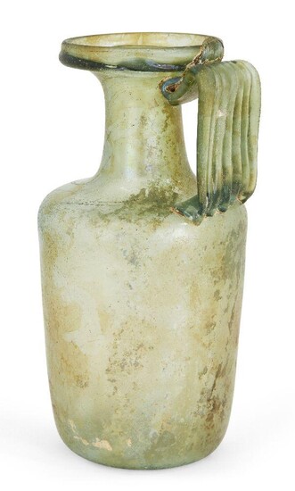 A Roman green glass flask, 1st-3rd century AD, on an indented base, rounded sides and ribbed handle, damage to shoulder, 18cm. high Provenance: Formerly in the collection of Frederick William Nash, acquired circa 1900