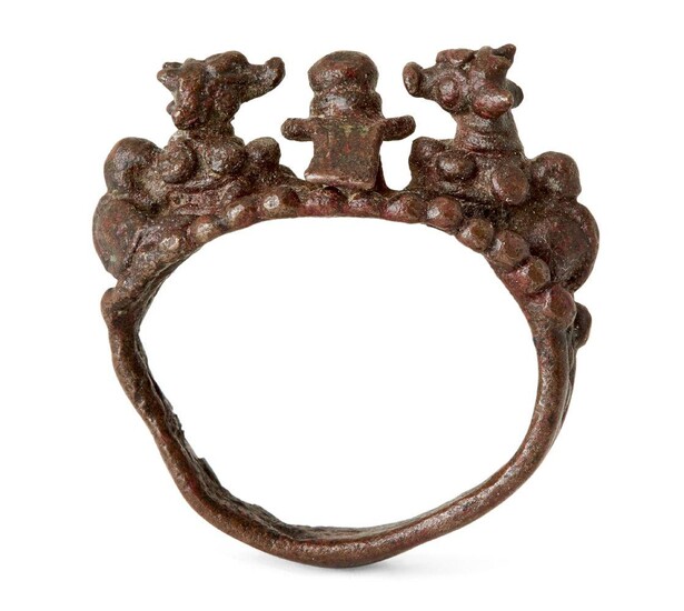 A bronze ring with nandi, India or possibly Java, 16th-17th century, the bezel with lingham and recumbant figure of Nandi either side, the plain shank slightly bent, 2.3cm. diam. Provenance: Private Collection Oliver Hoare (1945-2018)
