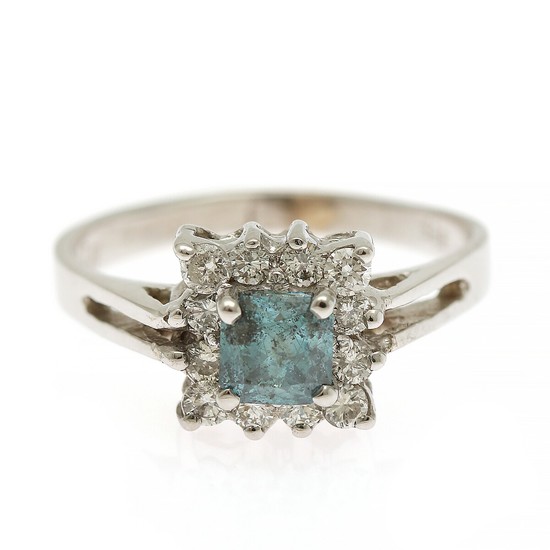 A diamond ring set with a princess-cut blue diamond encircled by numerous brilliant-cut diamonds totalling app. 0.90 ct. Size 52.