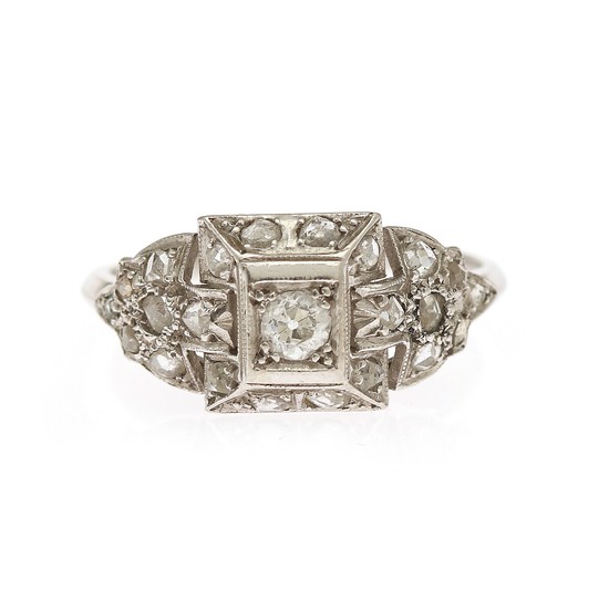 A diamond ring set with one old-cut diamond encircled by numerous rose-cut diamonds, mounted in platinum. Size 58.