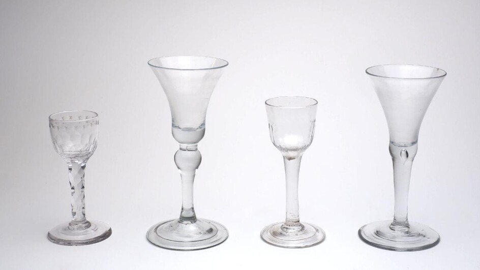 A group of wine glasses, 18th century, to include one with plain bell bowl and baluster stem, 18cm high, one with plain trumpet bowl and teardrop stem, one with fluted ogee bowl on plain stem and folded foot, 14cm high, and an engraved glass on...