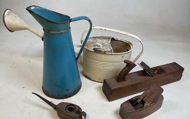 A large blue enamelled jug, a metal watering can, and...