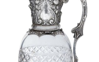 A late Victorian silver mounted claret jug, London, c.1891, Charles Edwards, the glass body with cross patterned bands and concave roundels and the silver collar decorated with floral and foliate patterns and vacant cartouches, the jug with hinged...