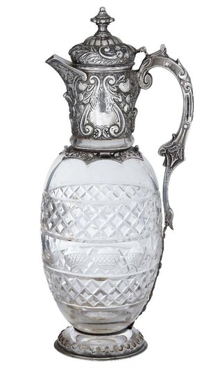 A late Victorian silver mounted claret jug, London, c.1891, Charles Edwards, the glass body with cross patterned bands and concave roundels and the silver collar decorated with floral and foliate patterns and vacant cartouches, the jug with hinged...
