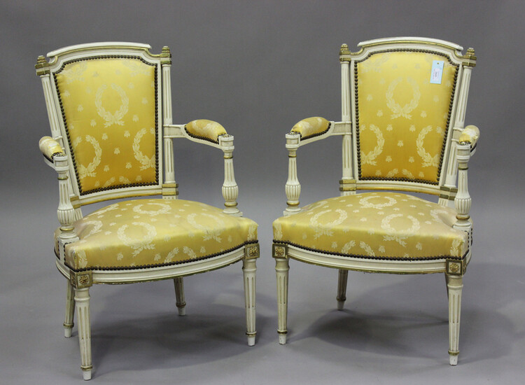 A pair of 20th century Louis XVI style white painted and gilt fauteuil armchairs, upholstered in pat