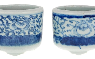 A pair of Chinese blue and white 'peony' incense burners, lian, mid Qing dynasty, each of cylindrical form standing on three short feet, painted to the body with a band of peonies among stylised foliage between blue borders, 8.5cm high. (2) 清中期...