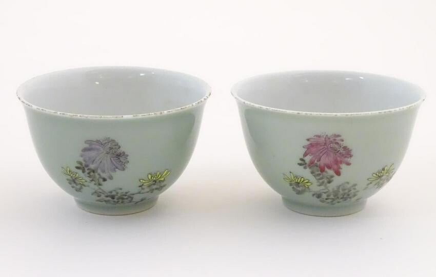 A pair of Chinese tea bowls decorated with flowers and