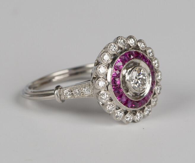 A platinum, diamond and ruby cluster ring, collet set with the principal circular cut diamond within