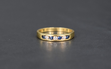 A sapphire and diamond half eternity ring having seven channel set stones on an 18ct gold loop, size