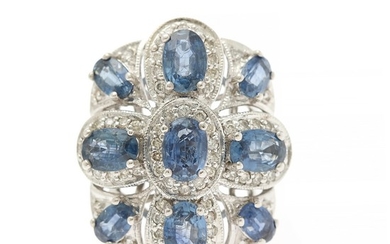 A sapphire and diamond ring set with nine oval-cut sapphires and numerous brilliant-cut diamonds, mounted in 18k white gold. Size 48.