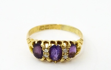 An 18ct gold ring set three graduated amethyst and four diam...