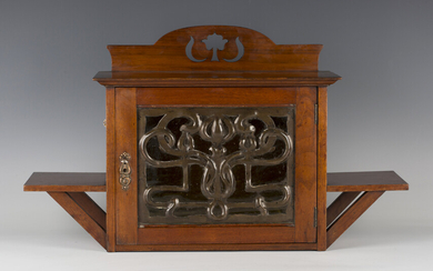 An Edwardian Arts and Crafts mahogany wall cabinet by Shapland & Petter of Barnstaple, the glaze