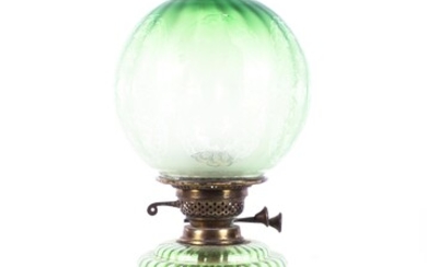 An Edwardian green glass oil lamp, the fluted shade etched with flowerheads and leafy branches