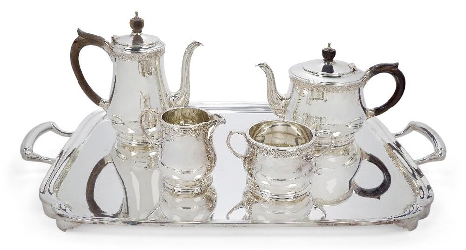 An Elizabeth II silver four-piece tea set with earlier tray, the tea set London, 1979, Wakely & Wheeler, each piece designed with a single scroll and medallion-studded band, the tea and coffee pots with wooden handles and finials, 15.5 and 20cm...