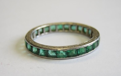 An Emerald Eternity Ring channel-set calibre-cut stones, stamped PLAT,...