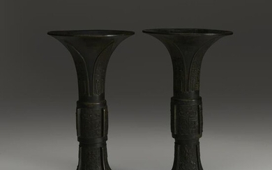 An associated pair of Chinese patinated bronze
