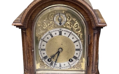 An early 20th century oak cased mantel clock with brass...