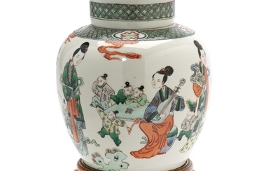 Chinese covered porcelain jar decorated in famille verte colours with playing children and court ladies. 20th century. H. 23 cm. Wooden stand incl.
