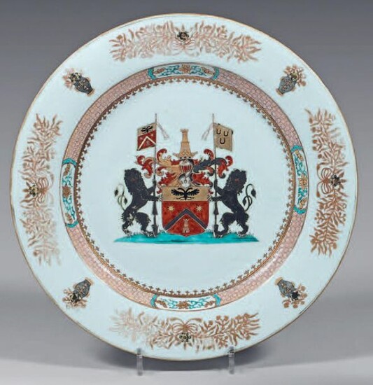 Chinese porcelain dish. Yongzheng-Qianlong, 18th century. Decorated with the enamels of the Rose Family, in the centre a coat of arms surmounted by a helmet and framed by two lions holding pennants in a medallion formed by a frieze of wrought iron...