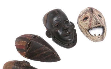 Four masks of carved patinated wood with traces of red, white, blue and black pigment. D. R. Congo style. H. 23–27 cm. (4)